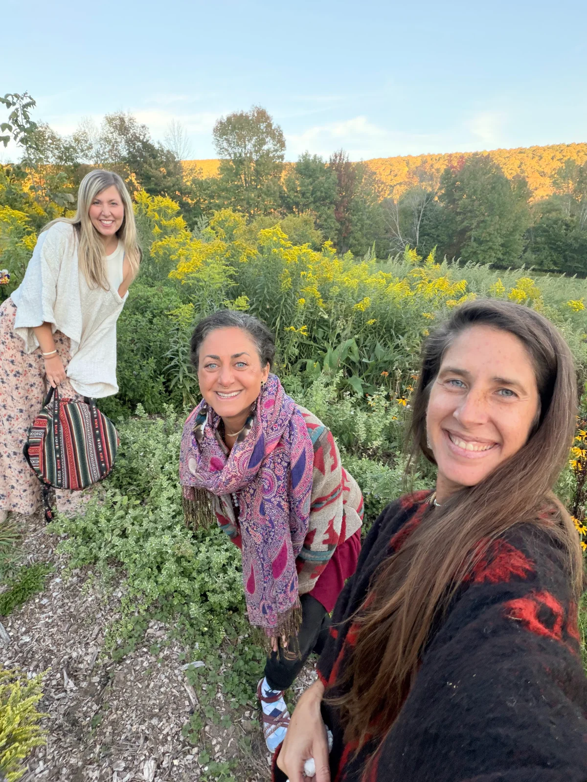 Sisters smiling in the wildflower meadow at golden hour